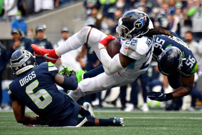 Tennessee Titans running back Derrick Henry (22) is tackled by Seattle Seahawks linebacker Jordyn Brooks (56) and strong safety Quandre Diggs (6) after making a reception during the fourth quarter at Lumen Field.